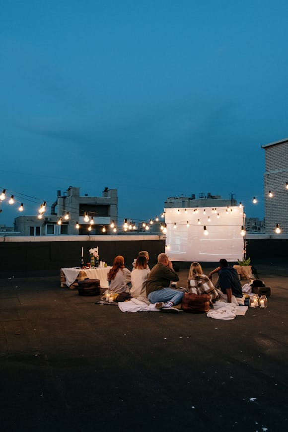 Proiettore su terrazza durante una serata cinema con amici